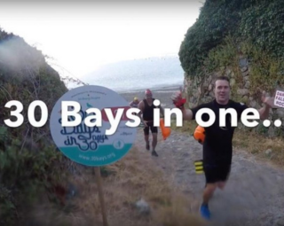 people running up a hill from the beach